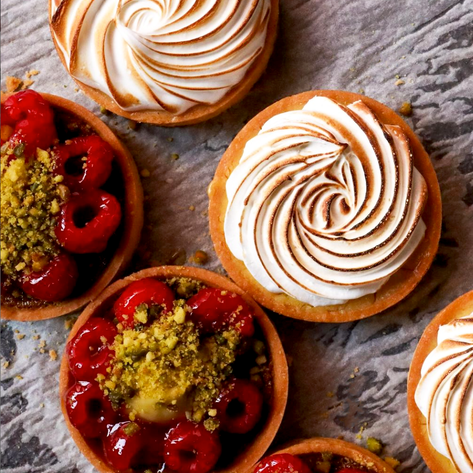 delicious sweet tarts freshly baked lemon meringue; and raspberry and pistachio.